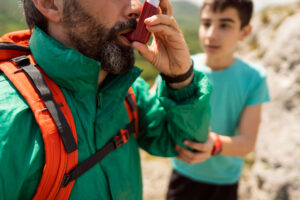 un hombre usando un inhalador para hacer un ataque de asma