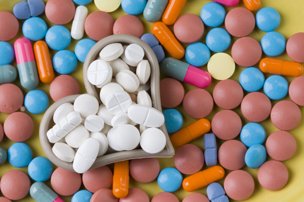 a heart shaped bowl filled with pills