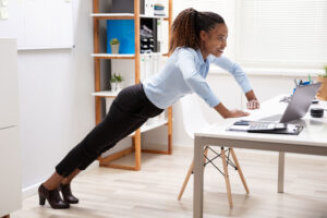 a woman doing push ups in an office