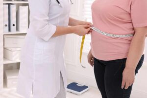 a doctor measuring a woman's waist