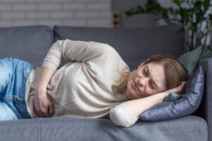 una mujer tumbada en un sofá con la cabeza apoyada en la mano