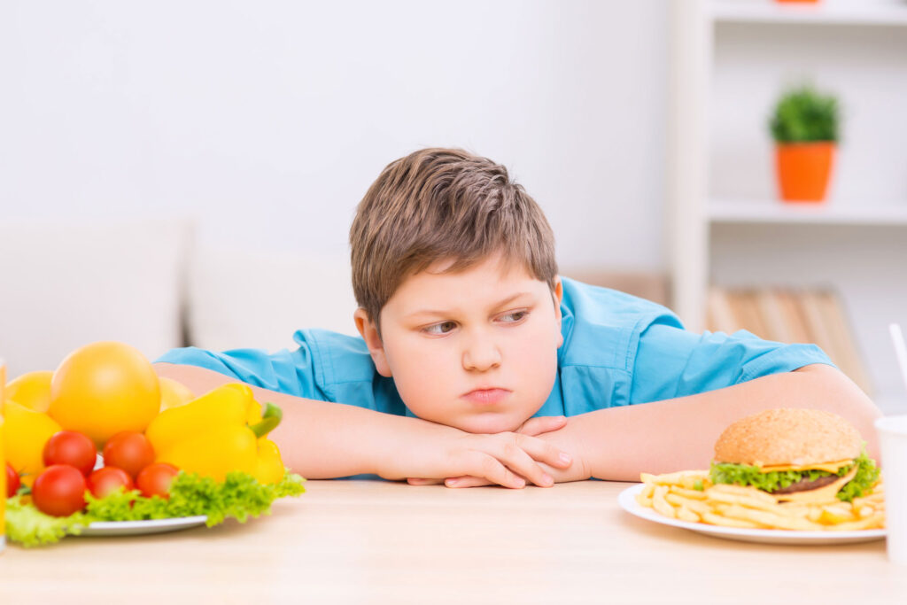 a boy looking at a plate of food