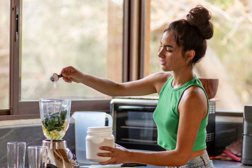 a woman pouring a blender into a jar