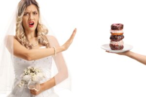 a woman in a wedding dress holding a plate of doughnuts