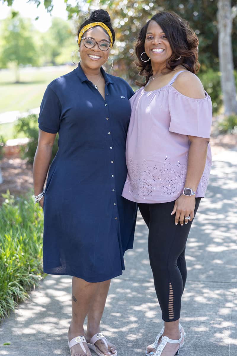 two women standing on a sidewalk