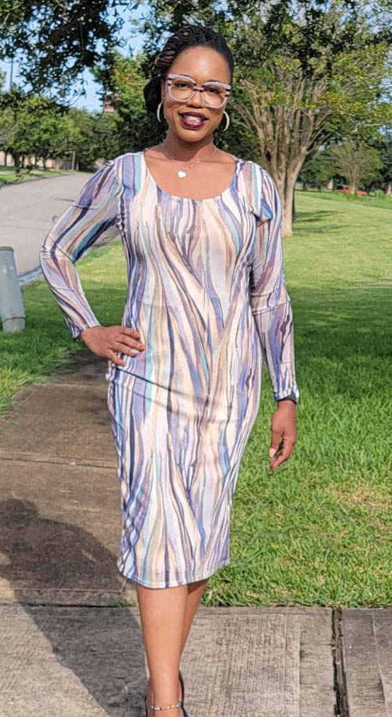 a woman in a dress standing on a sidewalk