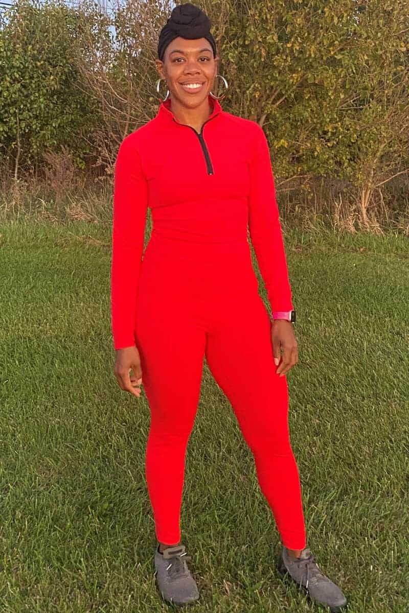 a woman in red outfit standing in grass