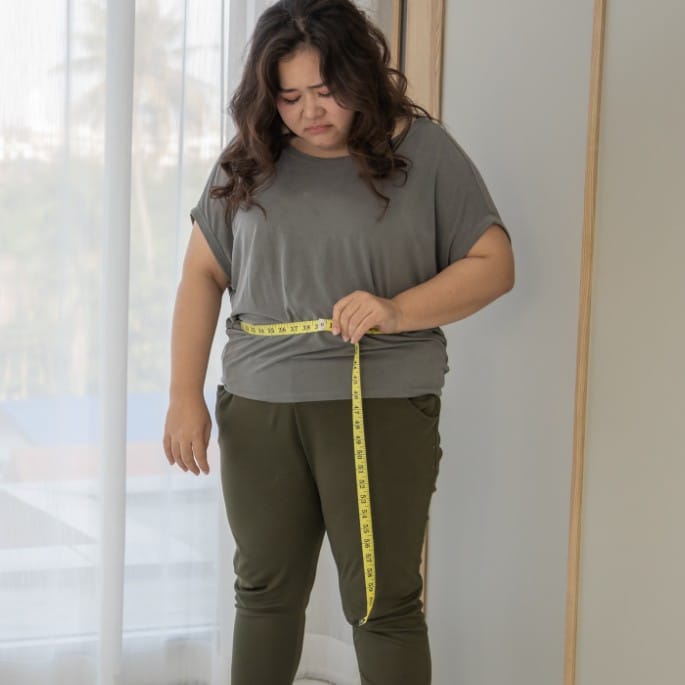 a woman measuring her waist