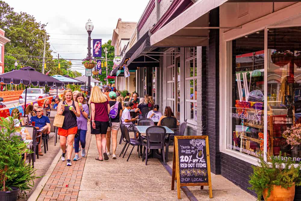 a group of people walking down a sidewalk